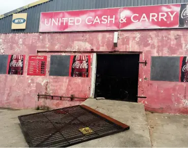  ??  ?? A security gate broken off the entrance to United Cash & Carry.