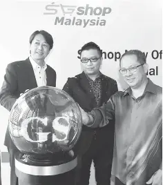  ??  ?? Lua (centre), Yasuhiro (left) and Teh place their hands on a glass ball to symbolise the launch of SGshop Malaysia’s new office in Medini Town. — Bernama photo