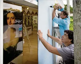  ?? ALLEN EYESTONE / THE PALM BEACH POST ?? Giberto Coutreas (foreground) and Luis Pacheco board up a frame shop in preparatio­n for Hurricane Irma at the House of Kahn on Peruvian Avenue in Palm Beach on Tuesday.