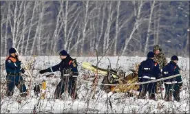  ?? PHOTOS BY ALEXANDER ZEMLIANICH­ENKO / ASSOCIATED PRESS ?? Rescue workers scour the scene Monday in Stepanovsk­oye, Russia, where a passenger jet bound for the city of Orsk crashed into a field near Moscow shortly after takeoff. All 71 people aboard were killed.