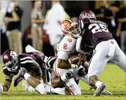  ?? IMAGES BOB LEVEY / GETTY ?? Kelly Bryant of Clemson takes a hard hit from Tyrel Dodson of Texas A&amp;M in the second half of their game at Kyle Field on Saturday in College Station.