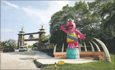  ??  ?? A pink statue of a hippo greets tourists at Hacienda Napoles Park.