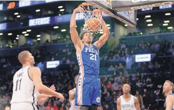  ?? SETH WENIG/ASSOCIATED PRESS ?? Philadelph­ia’s Joel Embiid (21) dunks against the Nets during Sunday’s game. The 76ers won 105-95 to improve to 10-25 this season, a year after going 10-72.
