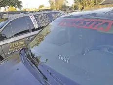  ?? FOTO CÉSAR NEYOY-BES ?? UNIDADES DE TAXI en el exterior del City Hall de San Luis, el pasado 28 de julio, cuando se aprobó la reducción de permisos a las compañías que operan en el area fronteriza.