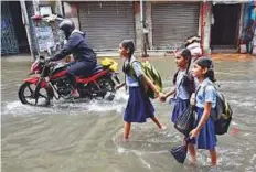  ?? PTI ?? Pupils wade through a waterlogge­d street after heavy rainfall, in Kolkata yesterday.
