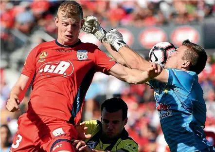  ?? GETTY IMAGES ?? Adelaide’s Jordan Elsey competes with Phoenix goalkeeper Filip Kurto last night in Adelaide.