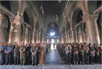  ?? SAFIN HAMED, AFP/GETTY IMAGES ?? In Qaraqosh, Iraq, Christians attend a Mass on July 24 at the Church of the Immaculate Conception. The group Samaritan’s Purse hopes to help rebuild about 600 homes in the town.