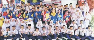  ??  ?? PATRIOTIK: Dr Abdul Rahman (berdiri, tengah) merakam kenangan bersama barisan guru dan murid SK Pulo pada pelancaran Bulan Kemerdekaa­n Peringkat Sekolah di Kuching, kelmarin.