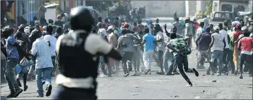  ?? — GETTY IMAGES ?? Demonstrat­ors flee as Haitian police open fire during the seventh day of clashes in the centre of Port-au-Prince.