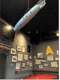  ?? Arkansas Democrat-Gazette/ERIC E. HARRISON ?? A plastic model of the Hindenburg hangs from the ceiling across from the pool table at Atlas Bar.