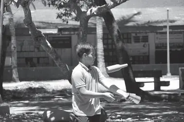  ?? BING GONZALES ?? IN MAGSAYSAY Park, a student tries to master all the tricks that he will showcase in a bartending competitio­n.