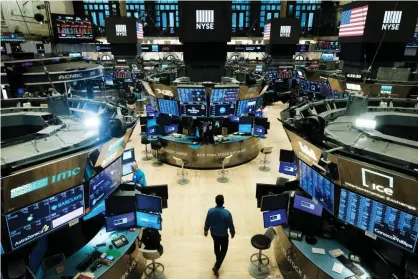  ??  ?? Traders work on the floor at the New York Stock Exchange on 20 March. Photograph: Spencer Platt/Getty Images