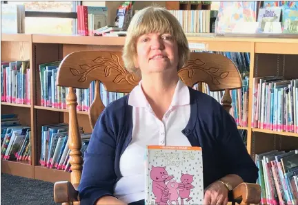  ?? SUBMITTED PHOTO — COURTESY OF NORTH WALES AREA LIBRARY ?? North Wales Area Library director Jayne Blackledge holds the children’s book “Happy Pig Day” before reading it for a Facebook Live stream meant to keep local kids engaged in reading while the library is closed.