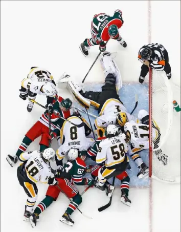  ?? Bruce Bennett/Getty Images ?? Somewhere in the mass of players, Penguins goalie Casey DeSmith makes one of his 24 saves Saturday in a 3-1 victory against the Devils in Newark, N.J.