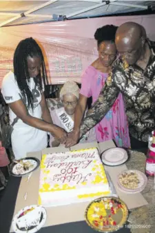  ?? ?? Mama gets help to cut one of her birthday cakes from her children (from left) Luseth, Delvarie, and Ivanhoe Boyd.