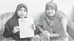  ??  ?? Sharifah Nurazmina (left) and her mother showing her PT3 2016 result slip.