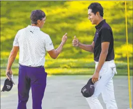  ??  ?? Rickie Fowler, left, and Hanbyeol Kim give each other thumbs up after finishing the second round of the CJ Cup at the Shadow Creek Golf Course on Friday.