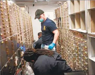  ?? U.S. District Court ?? AGENTS conduct a raid on U.S. Private Vaults last year. Over five days they seized more than $86 million in cash and a bonanza of gold, silver, rare coins, jewelry and luxury watches.