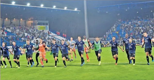  ??  ?? Los jugadores del Atalanta celebran con su afición el pase a octavos de Champions.