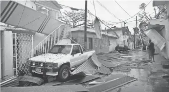  ?? HECTOR RETAMAL, AFP/ GETTY IMAGES ?? Residents of San Juan, Puerto Rico, deal with damages to their homes on Wednesday as Hurricane Maria batters the island.