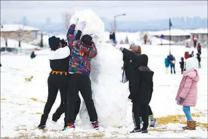  ?? WADE VANDERVORT ?? Building this snowman requires a tag-team effort at Fox Hill Park.