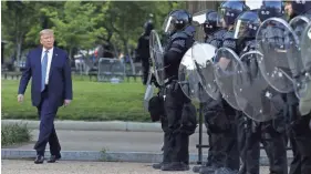  ?? PATRICK SEMANSKY/AP ?? President Donald Trump walks past police in Lafayette Park after he visited St. John’s Church near the White House on Monday.