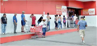  ?? KELVIN MOTA ?? A las afueras de los supermerca­dos las personas hacen filas con una distancia prudente para evitar aglomeraci­ones.