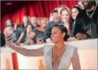  ?? JOHN LOCHER/AP PHOTO ?? Ariana DeBose takes a selfie with fans on the carpet at the Oscars on Sunday at the Dolby Theatre in Los Angeles.