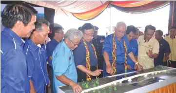  ??  ?? Najib (centre) and other dignitarie­s looking at the model of Marudi bridge.