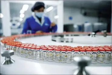  ?? ASSOCIATED PRESS FILE PHOTO ?? A Sinovac worker checks the labeling on vials of COVID-19 vaccines on a packaging line in Beijing.