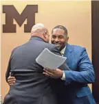  ?? DAVID RODRIGUEZ MUNOZ/DETROIT FREE PRESS ?? Sherrone Moore hugs U-M AD Warde Manuel, during a press conference in Ann Arbor on January 27.