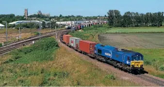  ?? ?? The single track between Ely and Soham (see also Passenger Review p86 and First Impression­s p12) remained a pinch point for cross-country intermodal trains to and from Felixstowe. DB Cargo loco No. 66148 heads east from Ely with 4L38, the 10.57 from East Midlands Gateway to Felixstowe Central, on July 16.