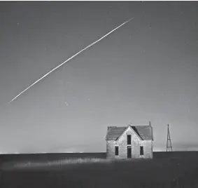  ?? REED HOFFMANN/AP ?? A string of SpaceX StarLink satellites passes over an old stone house Thursday near Florence, Kan., in a photo with a long exposure.