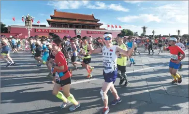  ?? LI NAN / FOR CHINA DAILY ?? Runners get going in the 2017 Beijing Marathon at Tian’anmen Square on Sunday. Some 30,000 took part.