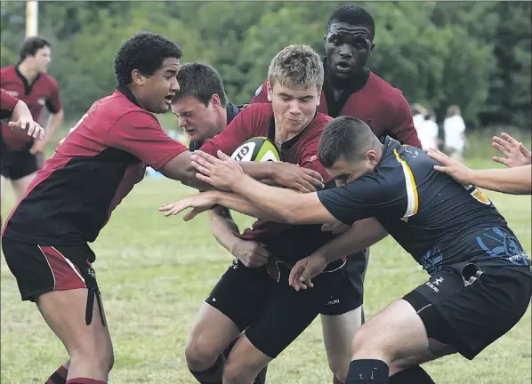  ?? — Photo by Rhonda Hayward/the Telegram ?? Sam Newhook of the Newfoundla­nd Staoil under-18 team carries the ball with support from teammates Malcolm Salmon (left), Kieran Lacey (background) and Nathan Thomas during Saturday’s male U18 semifinal against Nova Scotia at the Eastern Canadian rugby...