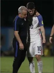  ?? REBECCA BLACKWELL — THE ASSOCIATED PRESS ?? Christian Pulisic, right, is comforted by a member of the team staff after the United States lost to Trinidad and Tobago in a World Cup qualifying match on Oct. 10 at Ato Boldon Stadium in Couva, Trinidad.