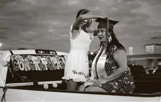  ?? Matthew Busch / Contributo­r ?? Caprice Diaz, 46, has her graduation tassel attached to her hat by her daughter Jessica, 12, as she celebrates her graduation from San Antonio College on Saturday night.