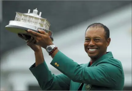  ?? MATT SLOCUM — THE ASSOCIATED PRESS ?? Tiger Woods wears his green jacket holding the winning trophy after the final round for the Masters golf tournament Sunday in Augusta, Ga.