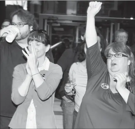  ?? Dean Bicknell, Calgary Herald ?? Tory supporters cheer as they watch early results come in at PC headquarte­rs at the Metropolit­an Centre in Calgary on Monday.