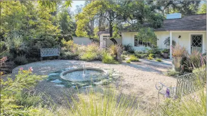  ?? Holly Lepere Grace Design Associates ?? A handsome fountain splashes in the center of a large gravel entrance courtyard.