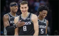  ?? Hector Amezcua / Sacramento Bee /TNS ?? The Sacramento Kings' Bogdan Bogdanovic (8) is congratula­ted by teammates Buddy Hield (24) and De'aaron Fox (5) after a win in overtime against the Brooklyn Nets at the Golden 1 Center in Sacramento on March 1, 2018.