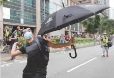  ??  ?? An anti-extraditio­n bill protester throws an egg at a police station in Tseung Kwan O residentia­l district, in Hong Kong. — Reuters