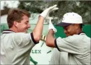  ?? LAURENT REBOURS — THE ASSOCIATED PRESS FILE ?? United States Ryder Cup team player Phil Mickelson, left, and Tiger Woods, right, high-five after Mickelson’s ball went in and out the hole during practice at the Valderrama golf course in southern Spain in 1997.