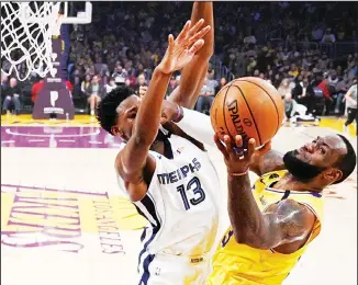  ??  ?? Los Angeles Lakers forward LeBron James, (right), shoots as Memphis Grizzlies forward Jaren Jackson Jr defends
during the first half of an NBA basketball game on Feb 21, in Los Angeles. (AP)