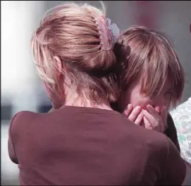  ?? Review-Journal file ?? A crisis interventi­on specialist, back to camera, hugs an Albertsons employee in the parking lot of the store following the shooting inside, which left four people dead and one wounded.