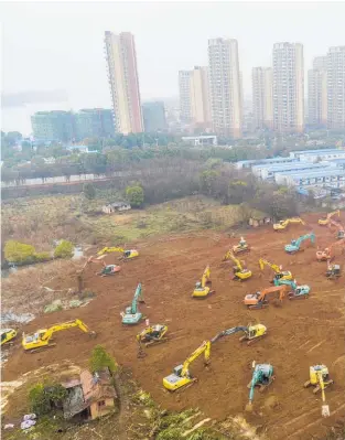  ??  ?? Heavy equipment prepares the site for a field hospital in Wuhan.