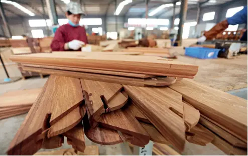  ??  ?? En la ciudad de Zaozhuang, provincia de Shandong, una trabajador­a hace la estructura de espiga y caja.