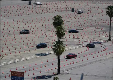  ?? (AP/Damian Dovarganes) ?? Vehicles follow the cones to line up at the Dodgers Stadium vaccinatio­n site Friday in Los Angeles. California has administer­ed nearly 19 million doses, and nearly 6.9 million people are fully vaccinated in a state with almost 40 million residents. But only people 50 and over are eligible statewide to get vaccinated now. More photos at arkansason­line.com/43covid19/.