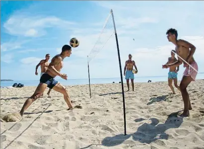  ?? ENRIQUE CALVO / REUTERS ?? Un grupo de jóvenes practica deporte en la playa de El Arenal, en Mallorca, que ayer entró en la fase 2