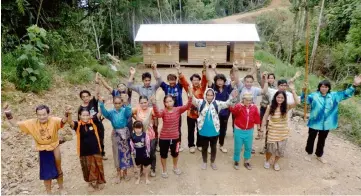  ??  ?? File photo shows Long Tevenga Penans in front of the house built by them across the logging road this year. The house serves as a blockade for them to stop the logging company from entering their area.